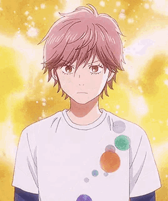 a boy with pink hair is wearing a white t-shirt with colorful circles on it .