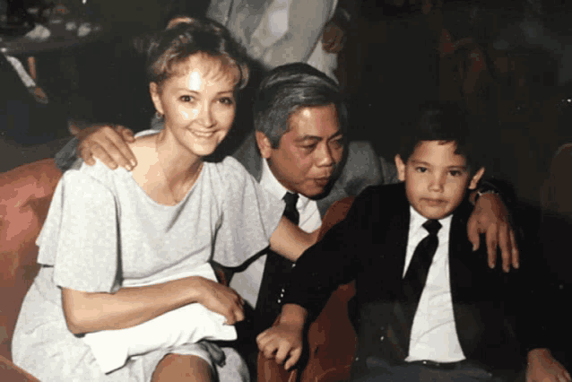 a man and a woman are posing for a photo with a young boy