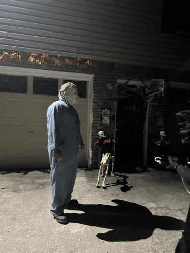 a man in a mask is standing in front of a garage