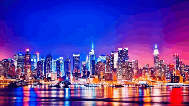 the skyline of new york city at night with the empire state building in the background