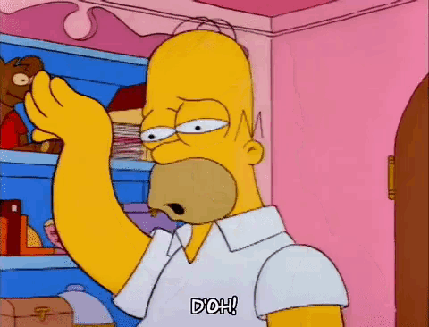 homer simpson from the simpsons is standing in front of a shelf and making a funny face .