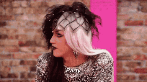 a drag queen is wearing a wig and a sequined top and says `` party '' .