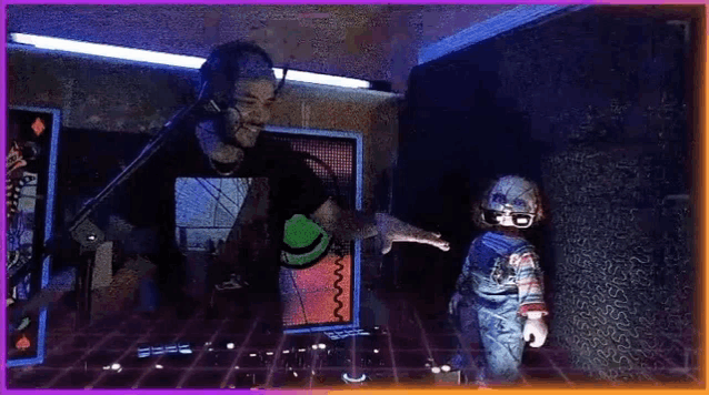 a man is playing a dj set in a dark room while a doll is standing next to him .