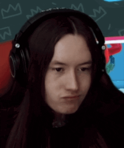 a woman with long hair wearing headphones making a funny face .