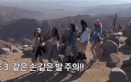 a group of women are standing on top of a rocky hillside with mountains in the background and a caption that says 3