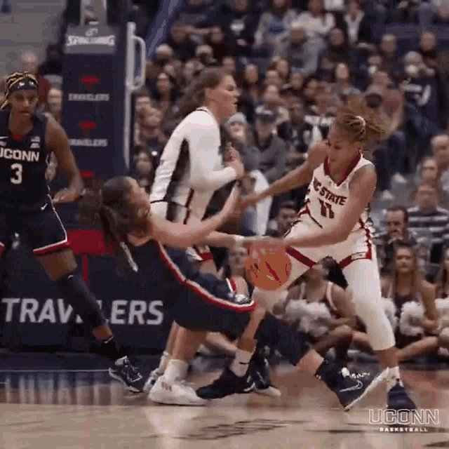 a group of women are playing basketball and one of them is wearing the number 11 on her jersey .