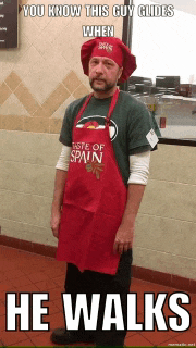 a man wearing an apron that says taste of spain is standing in front of a window