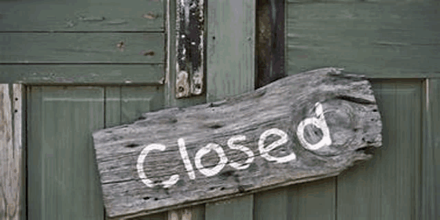 a wooden sign on a door that says `` closed '' .