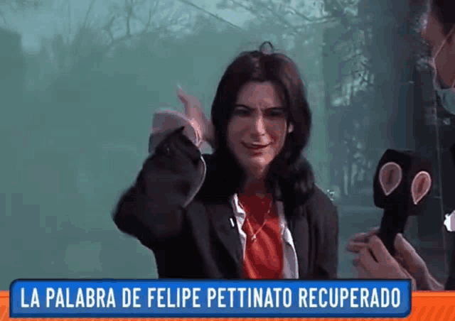 a woman in a red shirt is being interviewed by a man with a microphone and a sign that says la palabra de