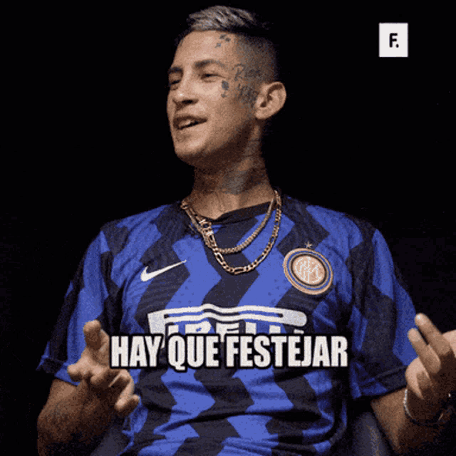 a man wearing a blue shirt that says hay que festejar on it