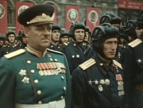 a group of men in military uniforms are standing in front of a sign that says ' soviet union ' on it