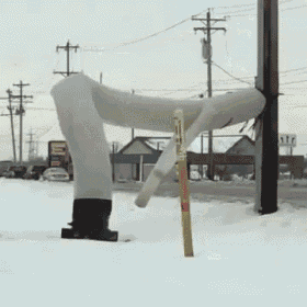 a statue of a person standing in the snow next to a pole with a sign that says ' a ' on it