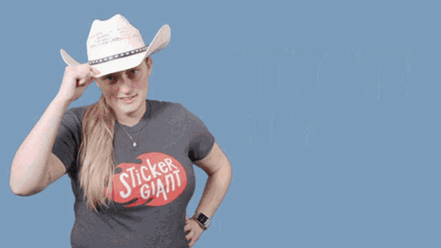 a woman wearing a cowboy hat and a sticker giant t-shirt says not my first rodeo