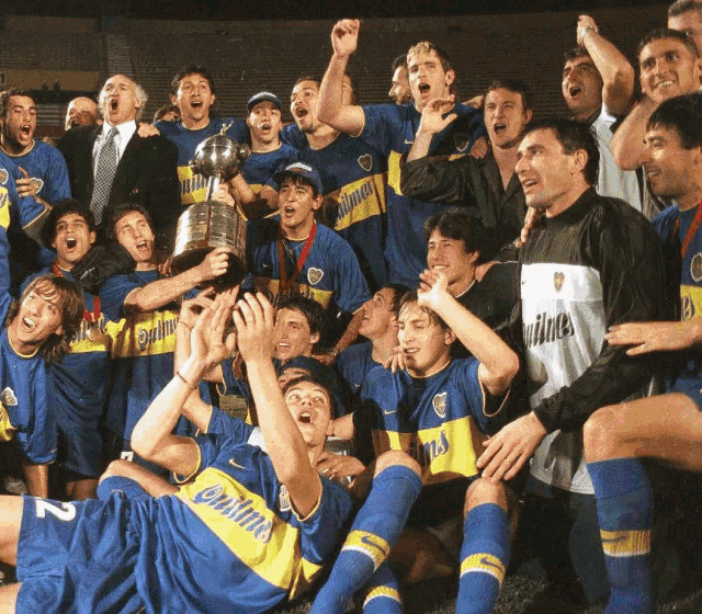 a group of soccer players are celebrating with a trophy and one player has the number 12 on his shirt