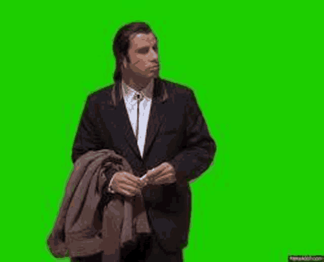 a man in a suit is standing on a green screen .