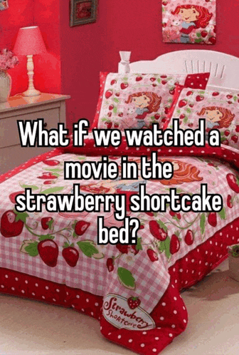 a bed with a strawberry shortcake blanket on it