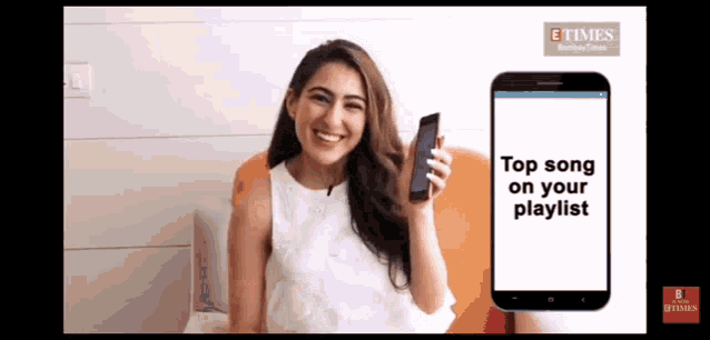 a woman is smiling while holding a phone with the words top song on your playlist on the screen