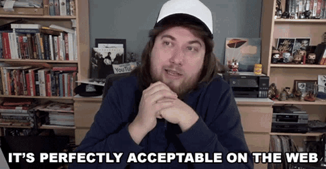 a man sitting in front of a bookshelf with the words " it 's perfectly acceptable on the web " below him