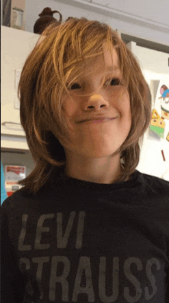 a young boy wearing a levi strauss shirt smiles for the camera