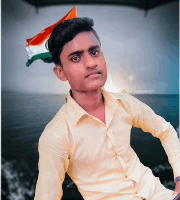 a young man in a yellow shirt is posing for a picture with a flag in the background