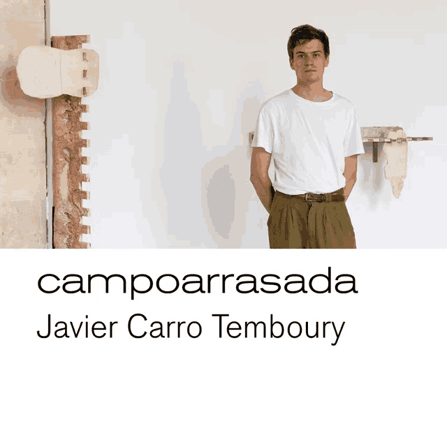 a man in a white shirt stands in front of a wall with the name campoarrasada javier carro temboury written on the bottom