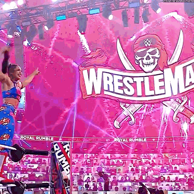 a woman is jumping in the air in front of a wrestlemania sign