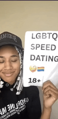 a girl holding a sign that says lgbtq speed dating 18+