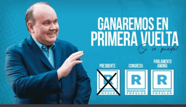 a man in a blue suit stands in front of a sign that says ganaremos en primera vuelta