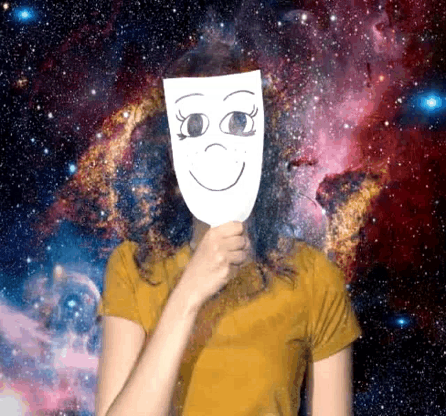 a woman is holding a mask with a smiley face on it