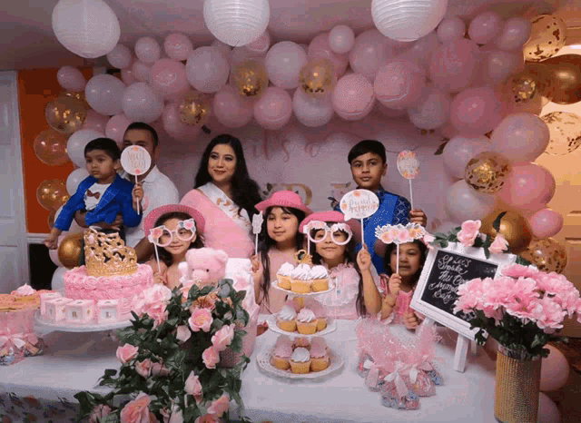 a group of people posing for a picture at a baby shower with a sign that says it 's a girl