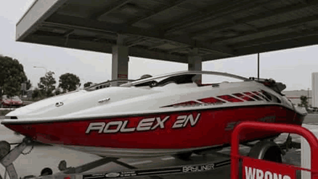 a red and white rolex 2n boat is on a trailer