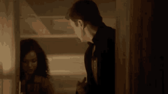 a man and woman are standing next to each other in a room .