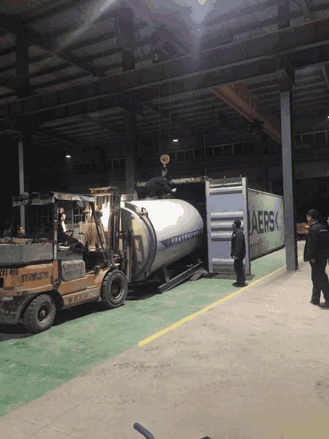 a container that says aersk is being loaded into a warehouse