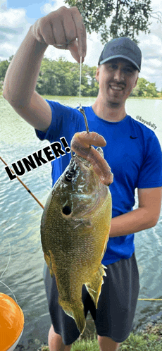 a man in a blue shirt is holding a fish with the words lunker written on it