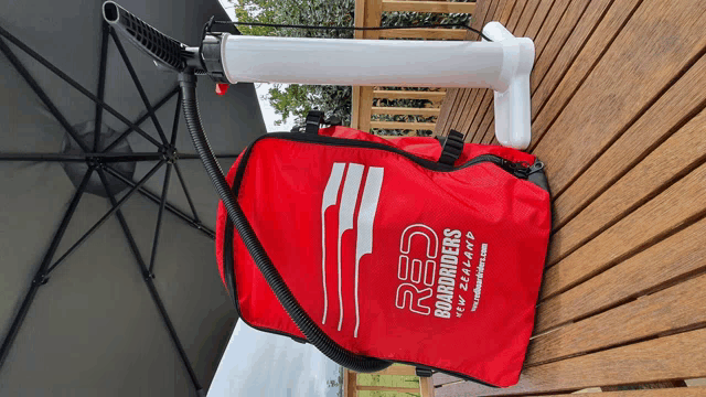 a red bag from red boardriders sits on a wooden deck