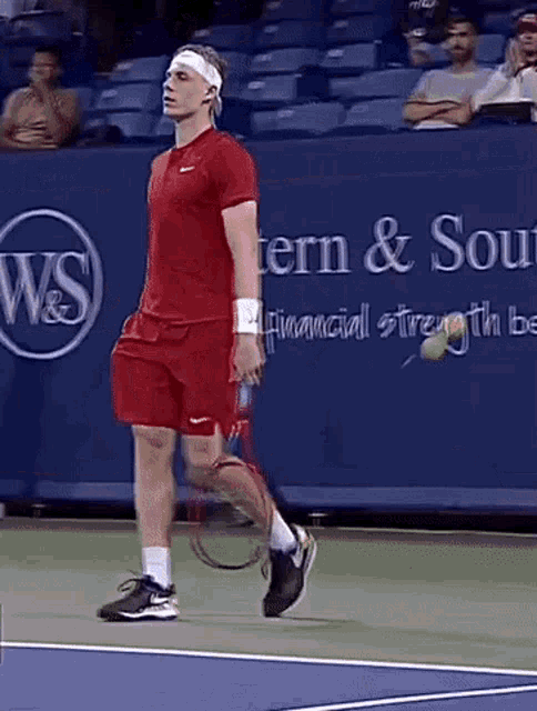 a man is holding a tennis racquet on a tennis court in front of a sign that says western & south