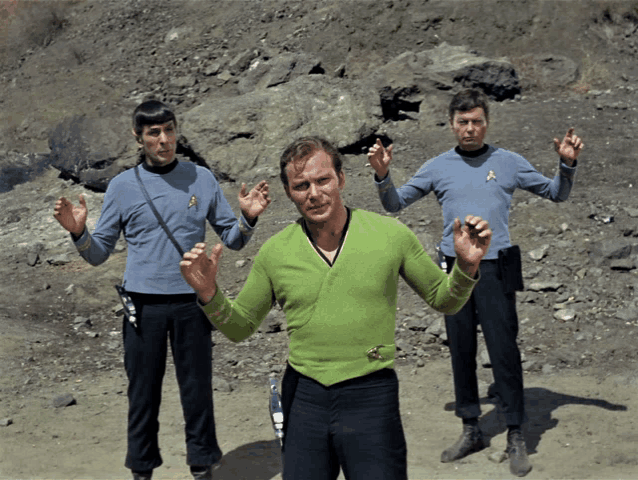 a man in a green sweater has a star trek badge on his chest