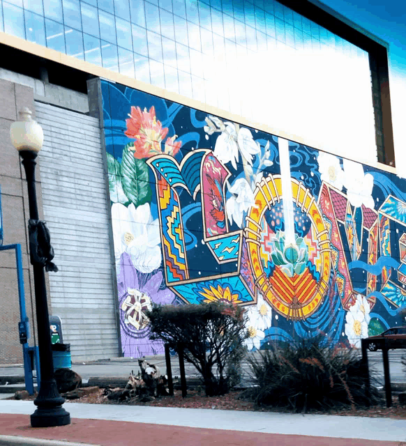 a colorful mural on the side of a building says love