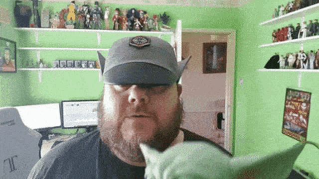 a man with a beard wearing a hat and sunglasses holds a stuffed animal in his hand