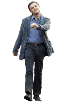 a man wearing a blue shirt and a grey jacket is walking