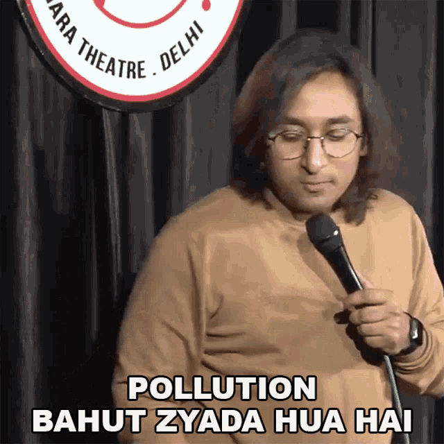 a man holding a microphone with the words pollution bahut zyada hua hai behind him