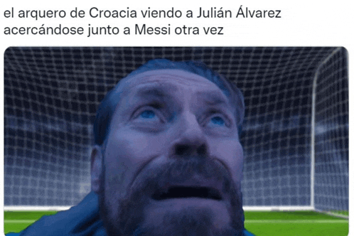 a man with a beard is looking up at the sky with a soccer goal in the background