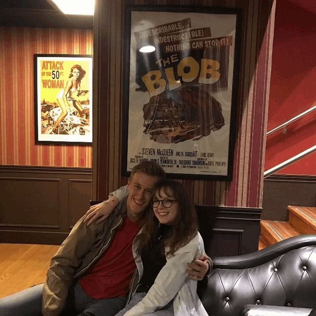 a man and a girl pose for a picture in front of a poster for the blob