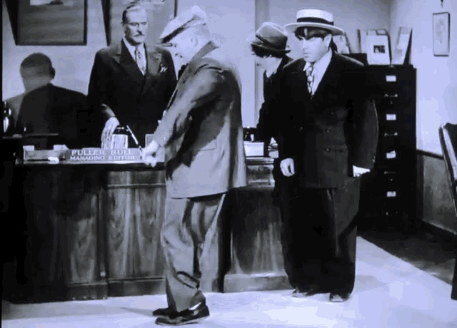 a black and white photo of a man standing in front of a desk that says public building managing editor