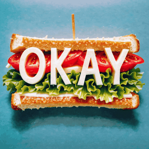 a sandwich with lettuce tomatoes and cheese says " okay "