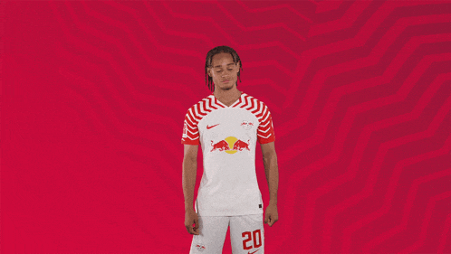 a soccer player wearing a red bull jersey and shorts