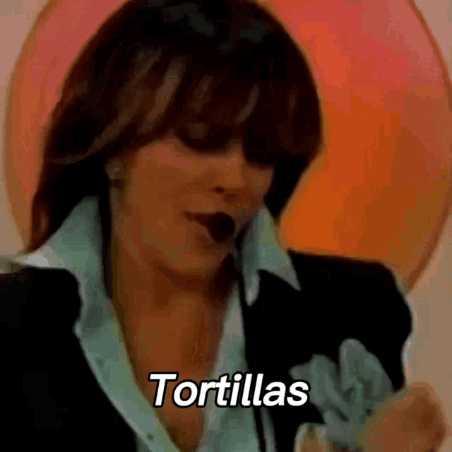 a woman is talking on a cell phone and the word tortillas is visible