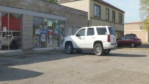 A white car parked in front of a store