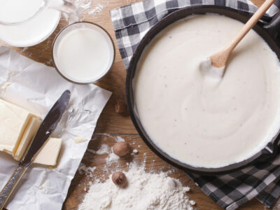 Roux in a cast iron pan with ingredients on the side.