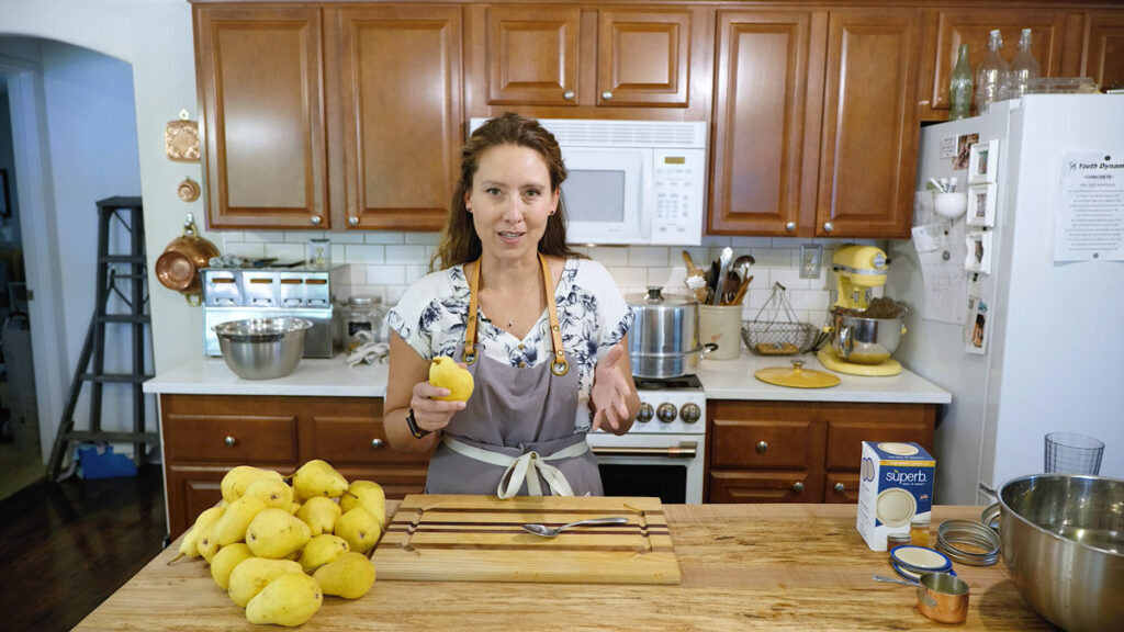 A woman holding pears, ready to can them.